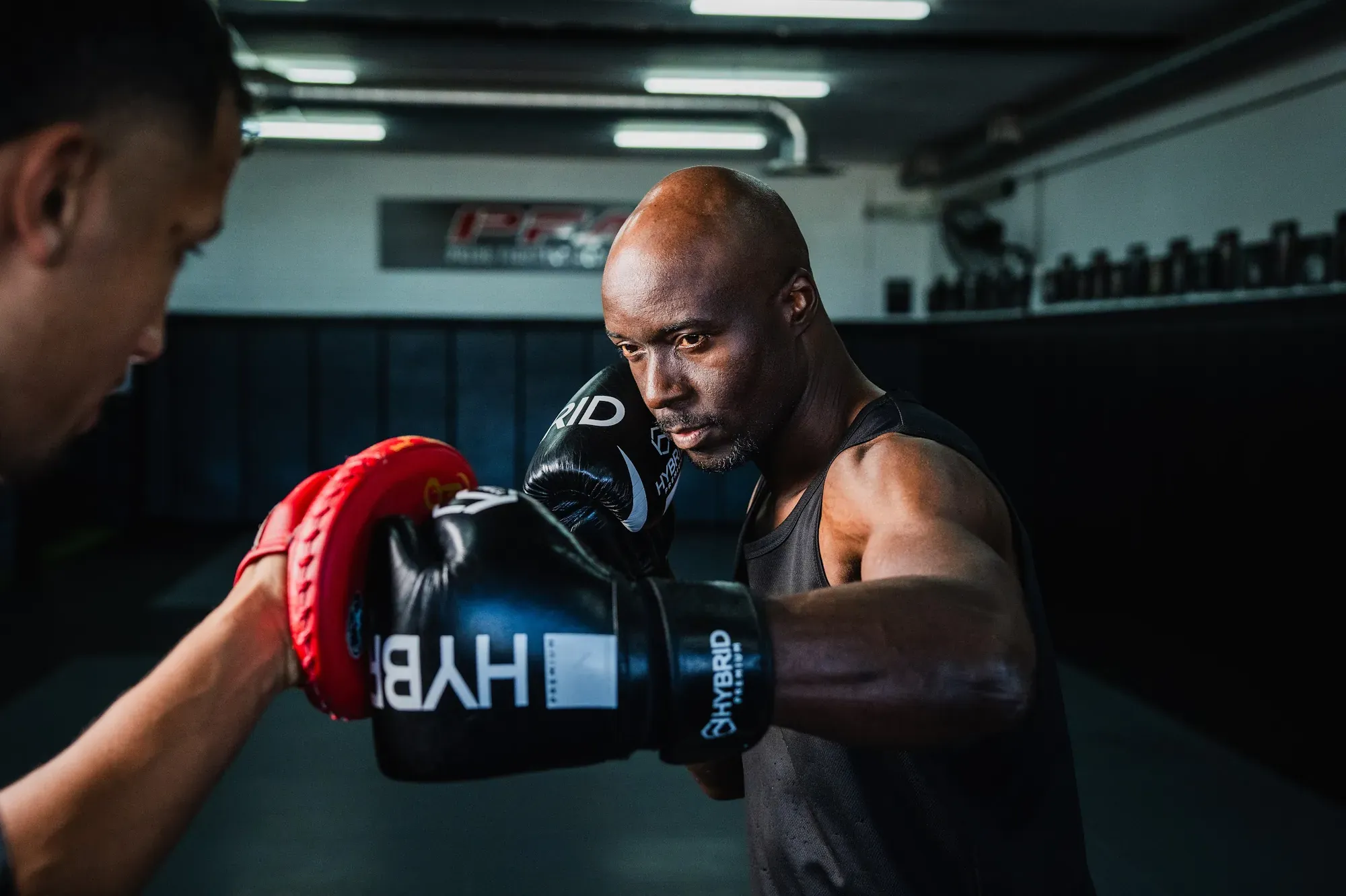 Boxer throwing a jab into a coach’s pad