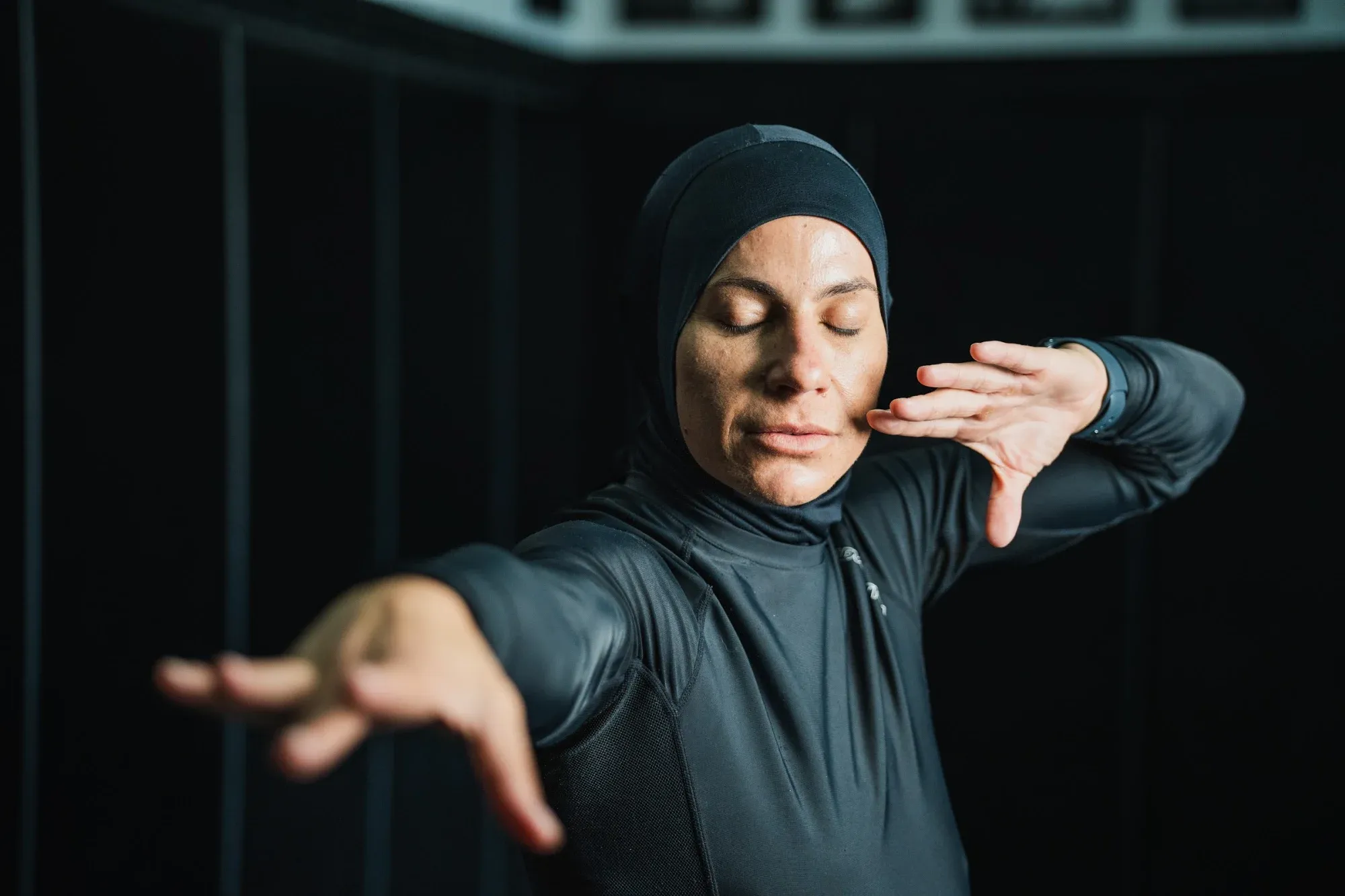 Yoga practitioner mid-movement in a dark studio