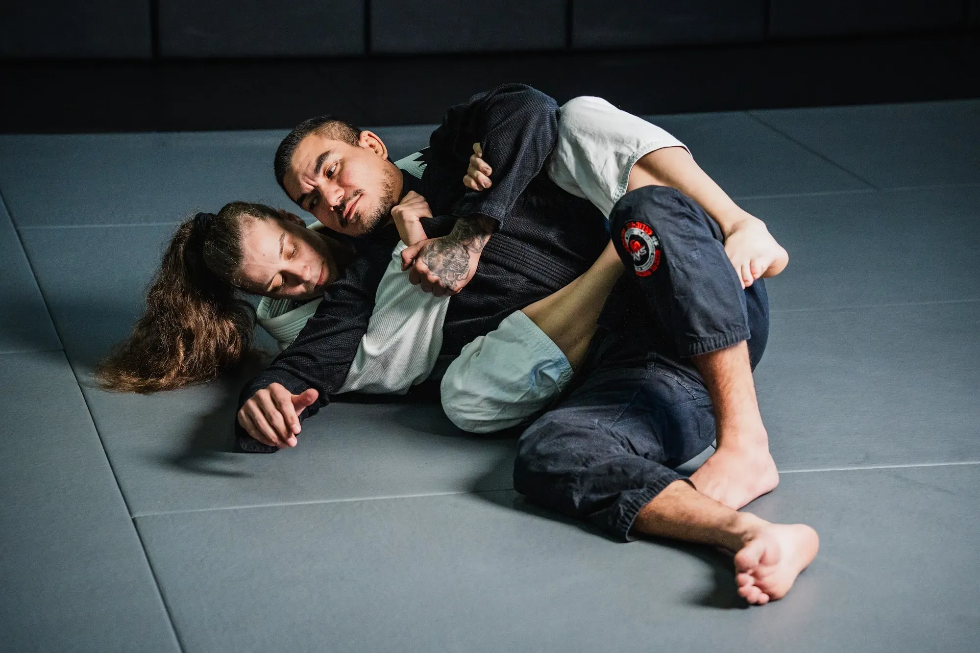 Two grapplers working guard on the PFA mats